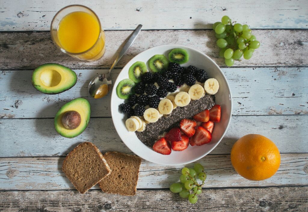 bowl of yogurt with kiwi, blackberries, banana slices, chia seeds, and strawberries. 