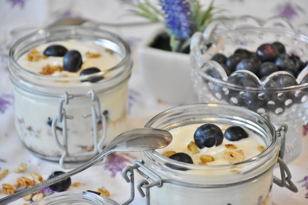 two jars of yogurt with blueberries and granola