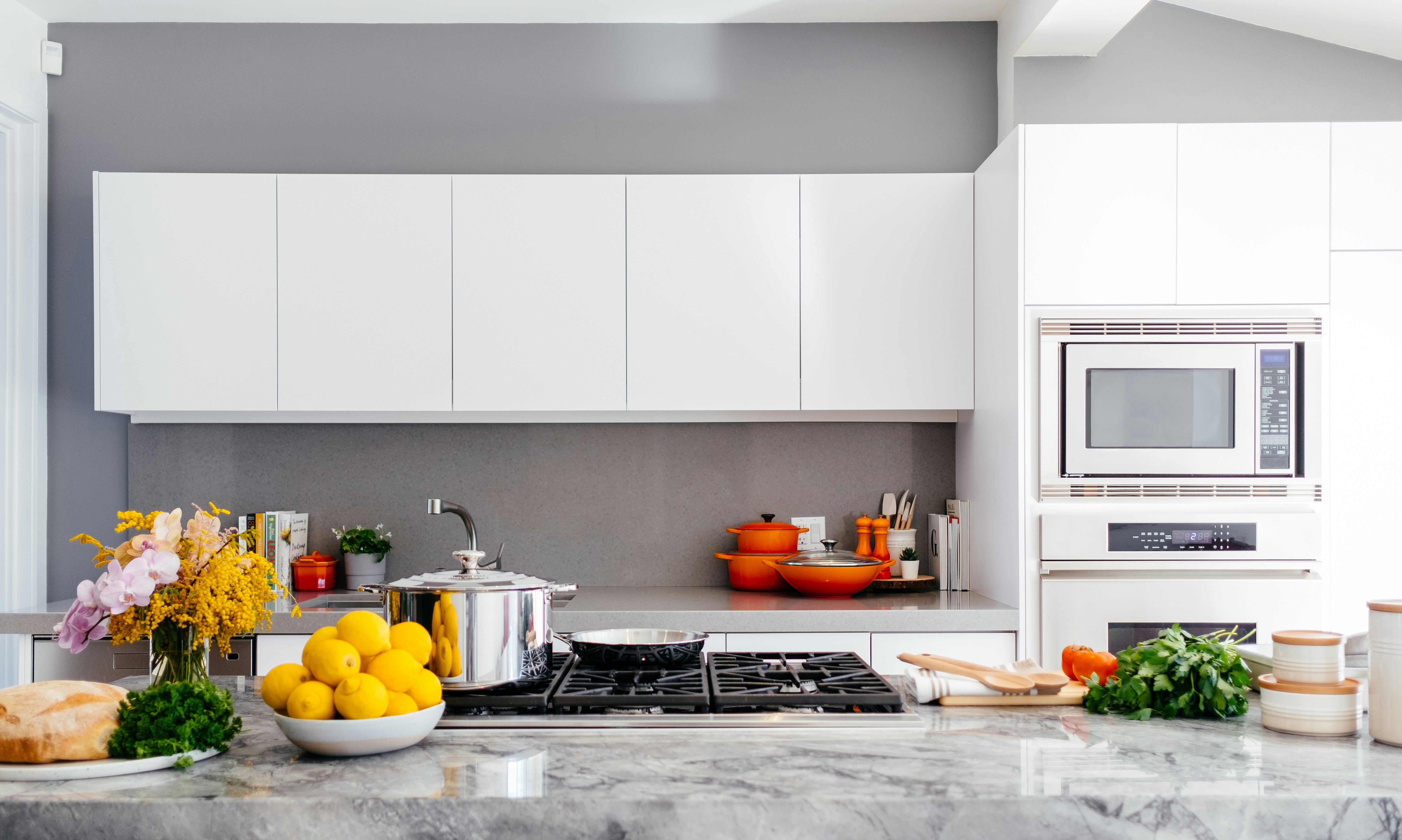 A bright kitchen with soup on the stove and lemons on the counter