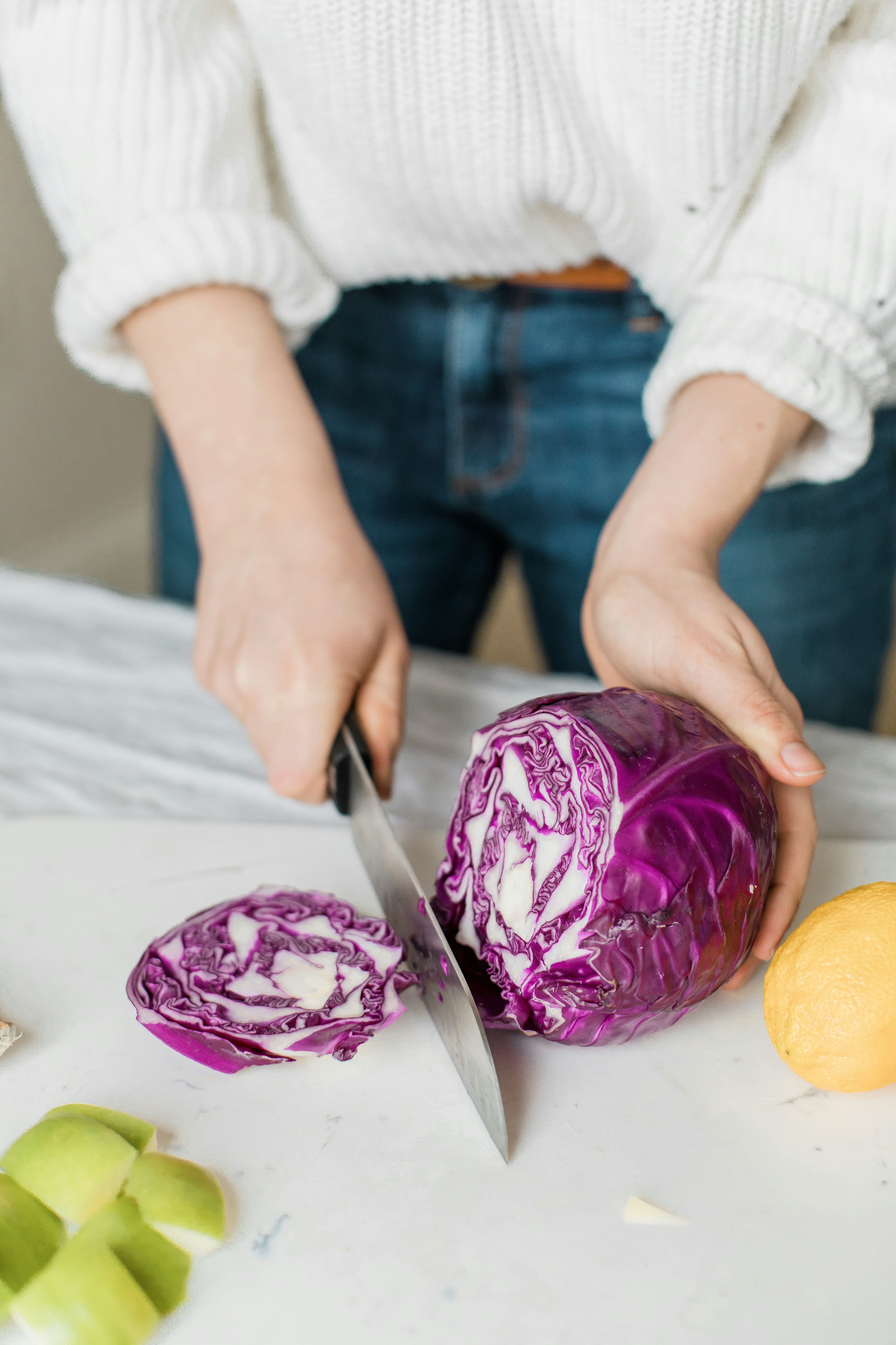 a woman chopping up red cabbage