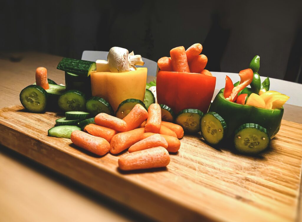 a vegetable train made out of bell peppers for the cars and cucumbers as the wheels